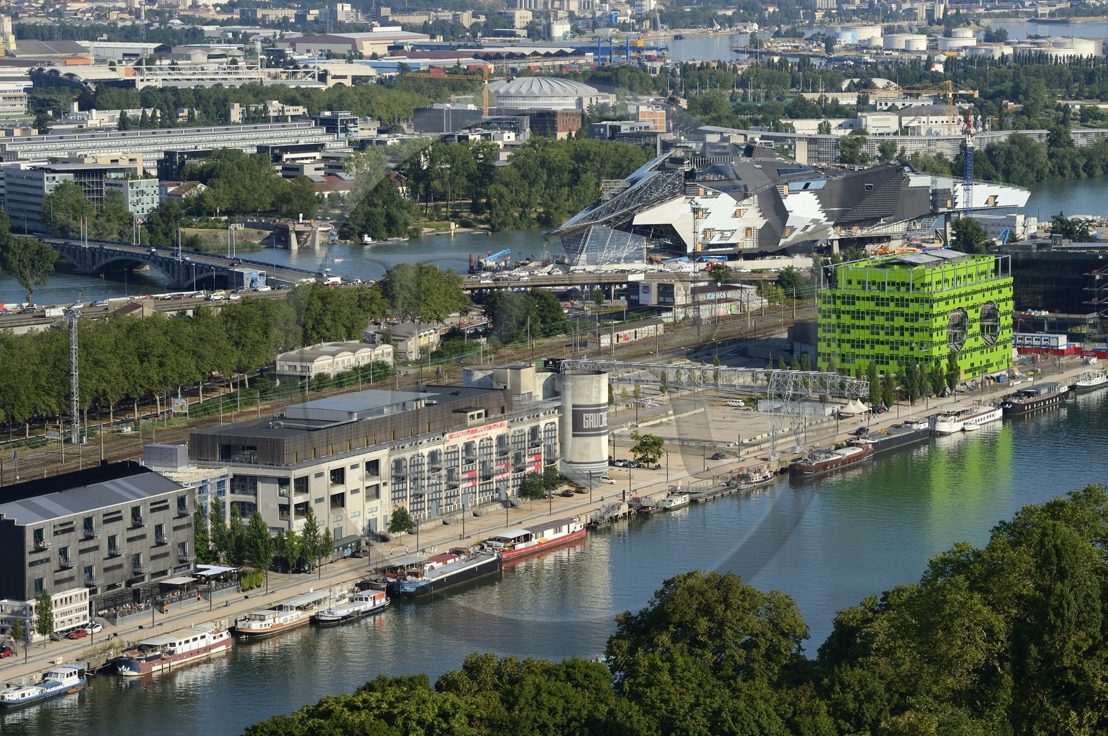 France, Rhône (69), Lyon, nouveau quartier de La Confluence au sud de la Presqu'île, Quai Rambaud, la Sucrière ancien entrepôt des années 1930 accueille depuis 2003 la biennale d'art contemporain et en arrière plan sur la droite le batiment vert siège d'Euronews et le chantier du futur musée des Confluences