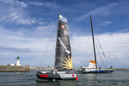 France, Vendee, Les Sables d'Olonne, a Mini 6.50 class monohull regatta sailing boat crosses Manuel Cousin's 60-foot monohull sailboat IMOCA Coup de Pouce at the entrance to the channel