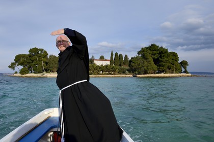 Croatie, Dalmatie, côte dalmate, Ile d’Ugljan, Preko, le frère franciscain Bozo Susic quittant le Monastère Franciscain de l'îlot Galovac sur sa barque