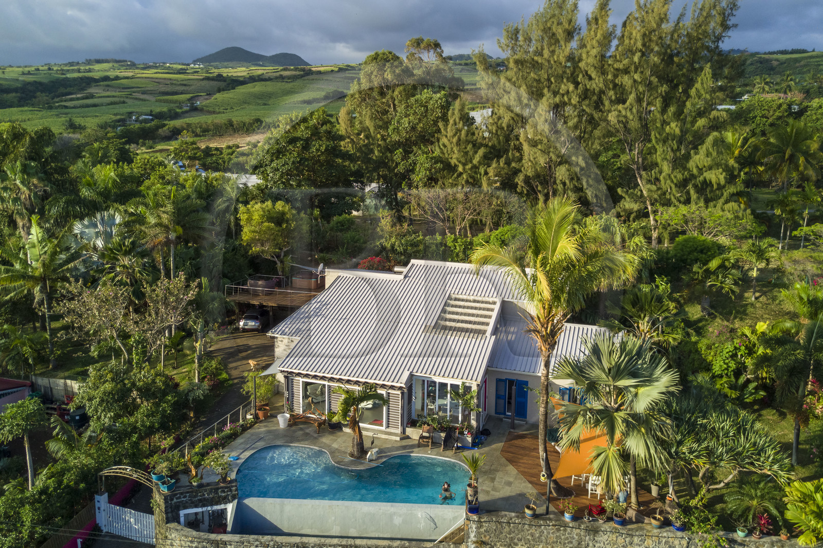 France, Reunion island (French overseas department), Petite-Ile, modern house and sugar cane fields in the background (aerial view)