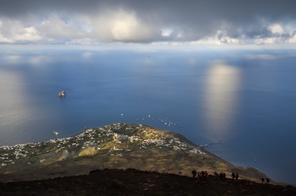 Italie, Sicile, iles Eoliennes, classées Patrimoine Mondial de l'UNESCO, ile de Stromboli, randonneurs dans l'ascension du volcan, le village de Stromboli et l'ilot de Strombolicchio en arrière plan