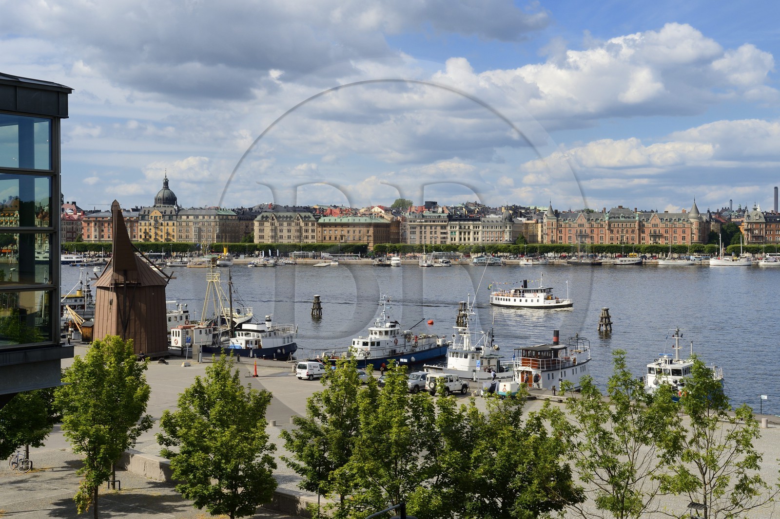 Sweden, Stockholm, island of Skeppsholmen, old boats moored at Östra Brobänken and Östermalm district with the prestigious avenue Strandvägen in the background