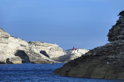 France, Corse du Sud, Bonifacio, the more than 60 meters high limestone cliffs and the lighthouse at the entrance of the cove