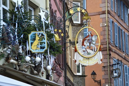 France, Haut-Rhin (68), Colmar, enseignes traditionnelles dans la Grand Rue avec des décorations de Noël