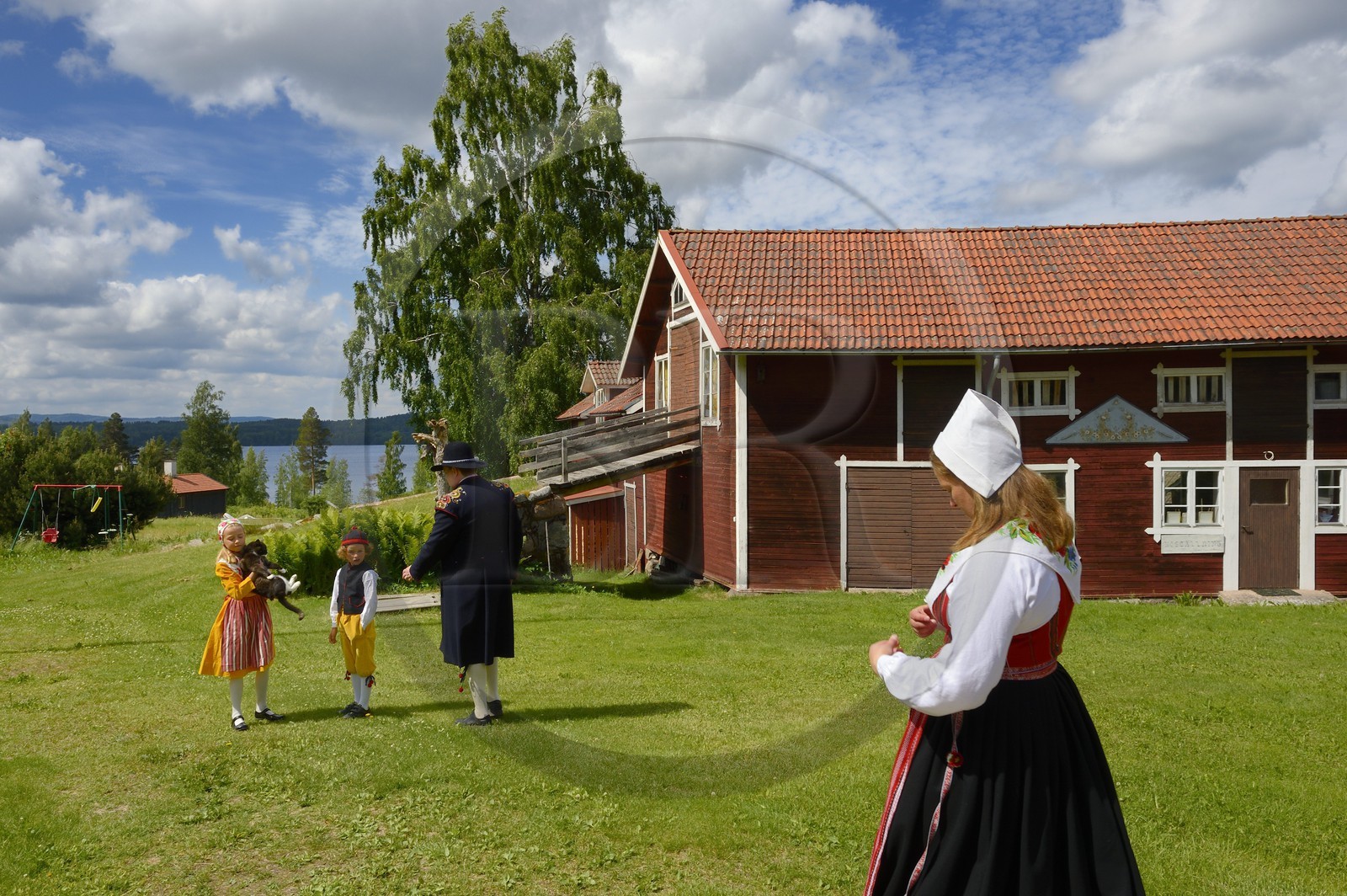 Sweden, Dalarna County, Leksand area, family in traditional costumes for the Midsummer celebrations in the tiny hamlet of Sunnanäng on the shore of Lake Siljan