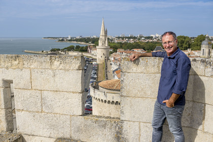 France, Charente-Maritime (17), La Rochelle, l'écrivain et historien local Mickael Augeron au sommet de la Tour Saint-Nicolas et la tour de la Lanterne en arrière plan
